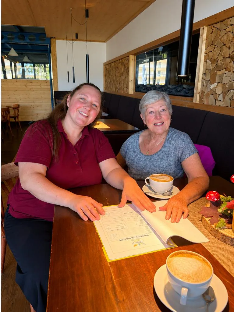 Tanja und eine Seniorin gehen gemeinsam die Unterlagen durch